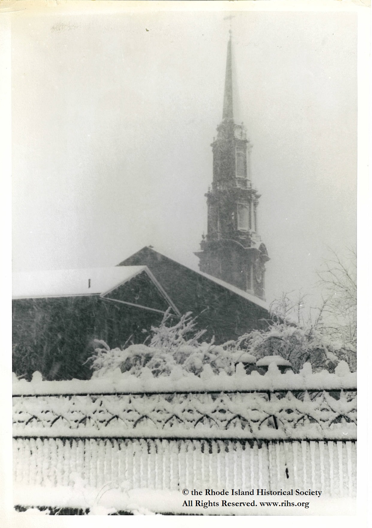 Estey, Charlotte (photographer). [View of the First Unitarian Church and Unitarian Hall from Benevolent Street, looking towards Benefit Street in the snow]. Providence, Rhode Island. 1945-1955. Photograph: Silver gelatin. Mary Elizabeth Robinson Research Center, G Lot 144, Charlotte Estey Collection.